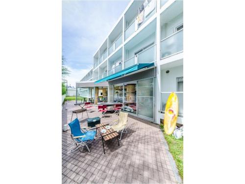 a building with a patio with chairs and a table at 365BASE outdoor hostel in Hamamatsu