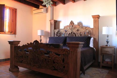 a bedroom with a bed with a wooden frame at Hotel Casa Oratorio "Adults Only" in San Miguel de Allende