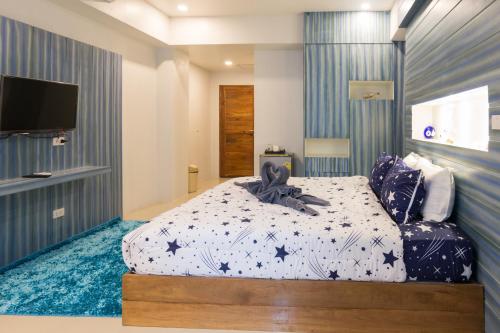 a bedroom with a bed and a flat screen tv at 2 Feel Bed Station in Udon Thani