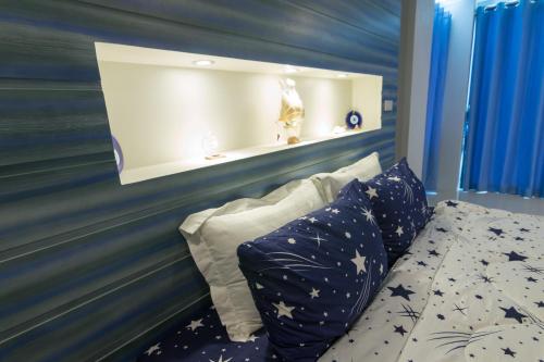 a bedroom with a blue wall with a bed and pillows at 2 Feel Bed Station in Udon Thani