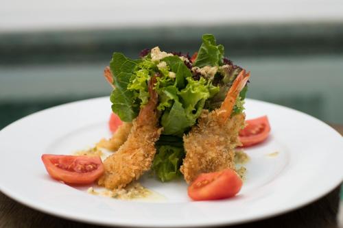a plate of food with lettuce and tomatoes on it at SAKABAN Suite in Siem Reap