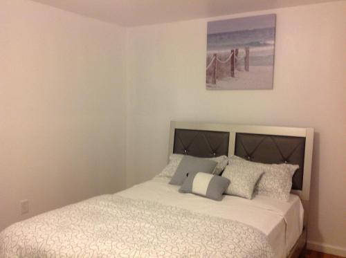 a bedroom with a large bed with white sheets and pillows at Mojoy Homesuites At Runyon in Newark