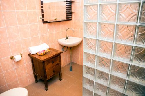 a bathroom with a sink and a toilet and a mirror at Casa do Sândalo Boutique Guest House in Dili