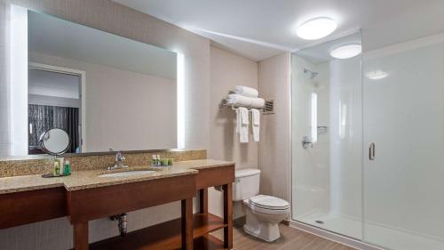 Holiday Inn Express & Suites Cincinnati Riverfront, an IHG Hotel في كوفينغتون: حمام مع مرحاض ومغسلة ودش