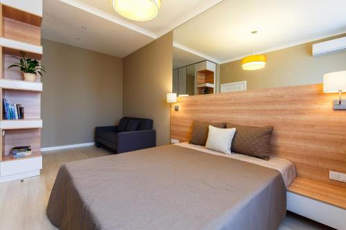 a bedroom with a large bed and a chair at Eco Apart Hotel Astana in Astana