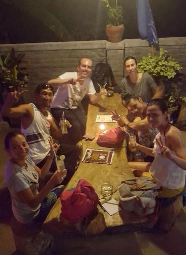 a group of people sitting around a wooden table at Apollo Hostel in Lovina