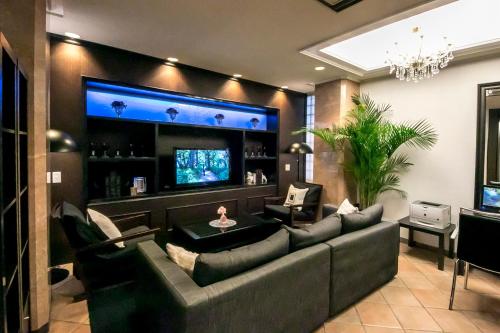 a living room with a couch and a television at Grand Park Hotel Panex Tokyo in Tokyo