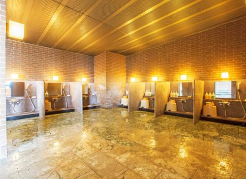a bathroom with multiple urinals in a room at Fruit Park Fujiya Hotel in Yamanashi