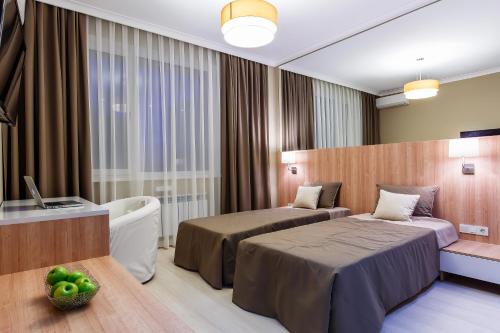 a hotel room with two beds and a television at Eco Apart Hotel Astana in Astana