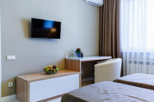 a hotel room with a bed and a desk with a television at Eco Apart Hotel Astana in Astana