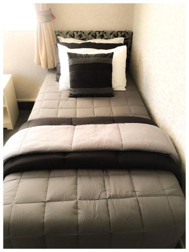 a large bed in a bedroom with a pillow at Deco City Motor Lodge in Napier