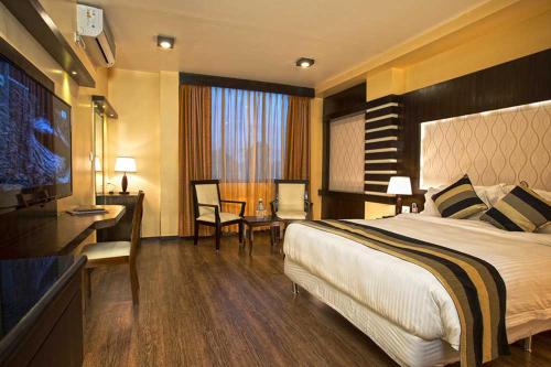 a hotel room with a bed and a desk at United Business Hotel in Kathmandu