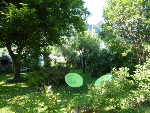 two green chairs sitting in the grass in a garden at casa la resega in Gravedona