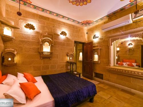 a bedroom with a bed and a large mirror at Fort Villa in Jaisalmer