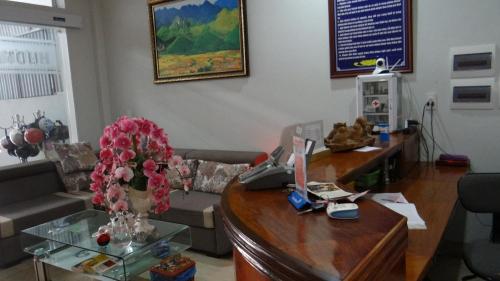 a living room with a couch and a desk with a phone at Huong Thao 2 Hotel in Ha Giang