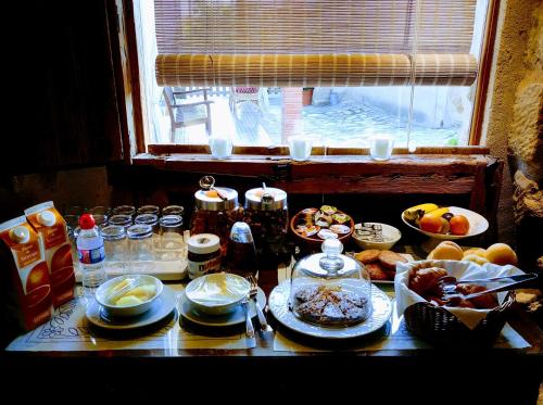 een tafel met borden vol eten en een raam bij Torre Alta de Ram in Alcañiz