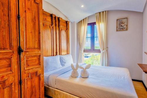 two rabbits sitting on a bed in a bedroom at Venetian Resort Pattaya in Jomtien Beach
