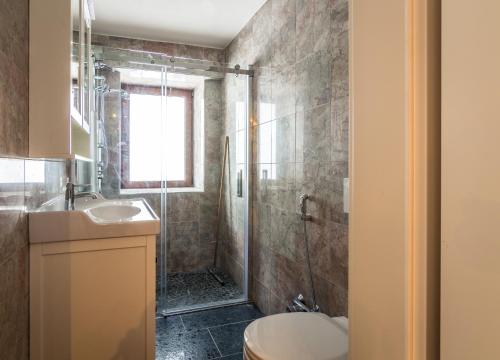 ein Badezimmer mit Dusche, Toilette und Waschbecken in der Unterkunft Villa Gastuna in Bad Gastein