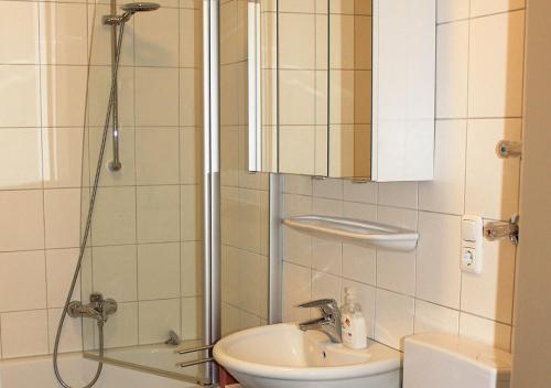 ein Bad mit einer Dusche und einem Waschbecken in der Unterkunft Apartment Köln Weiden in Köln