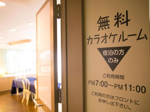 a door with a sign in a room with a table at hotel miura kaen in Takikawa