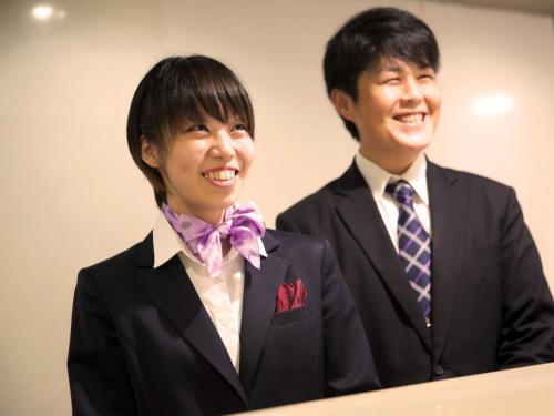 
two people wearing suits and ties standing next to each other at hotel miura kaen in Takikawa

