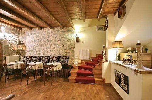 un restaurante con mesas y sillas y una chimenea en Archontiko tis Zois en Stemnitsa