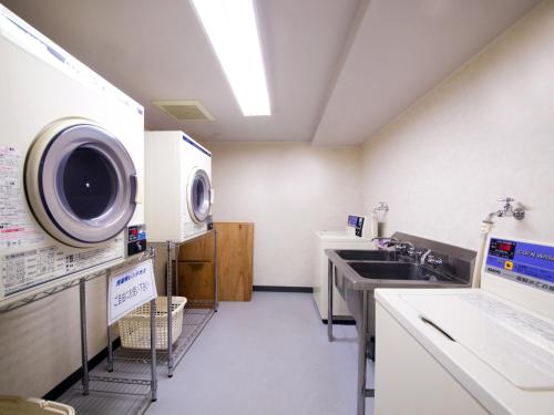uma lavandaria com um lavatório e uma máquina de lavar roupa em hotel miura kaen em Takikawa