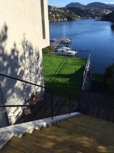 a balcony with a view of a river and a boat at Knudsen Apartment in Bergen