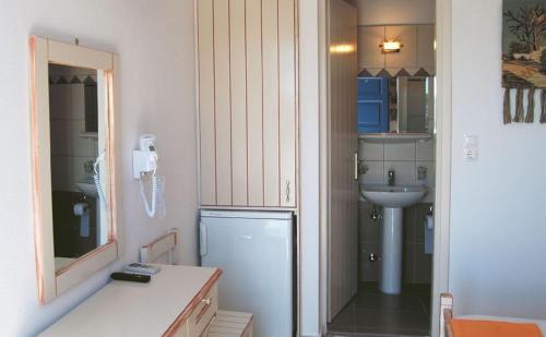 a small bathroom with a refrigerator and a sink at Melissa Chora in Koufonisia