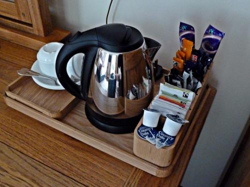 a black coffee pot sitting on a wooden shelf at Stocks Hotel in Sark
