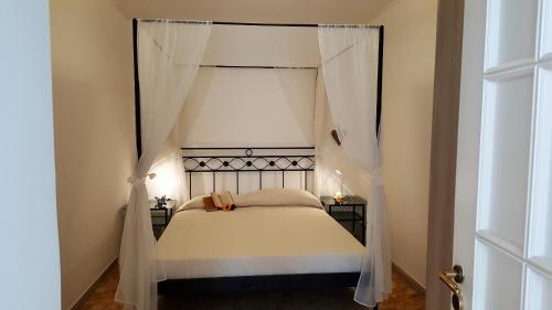 - une chambre avec un lit à baldaquin et des rideaux blancs dans l'établissement Casa Agrumeto by Holiday World, à Gênes