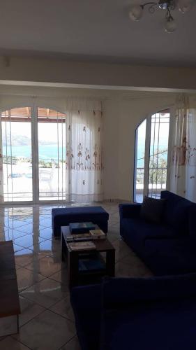 a living room with blue couches and a table at Olympic View Guesthouse in Kalami