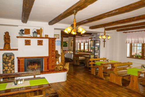 a restaurant with a fireplace and wooden tables at Wellness hotel Chata Jana in Lopeník