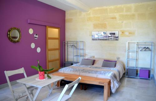 1 dormitorio con 1 cama, mesa y sillas en Maison d'Hôtes La Prévôté, en Périssac
