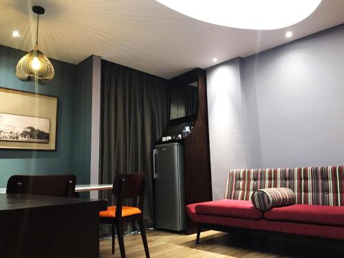a living room with a red couch and a refrigerator at Mercure Surabaya Grand Mirama in Surabaya