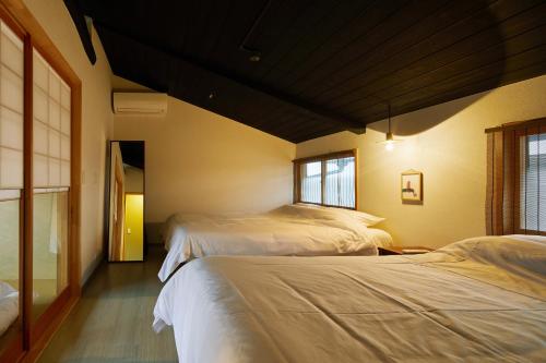 1 Schlafzimmer mit 2 Betten und einem Fenster in der Unterkunft Nakano-an in Kyoto