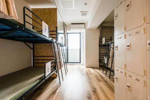 大阪市にある04village Nambaの二段ベッドと廊下が備わるドミトリールームです。