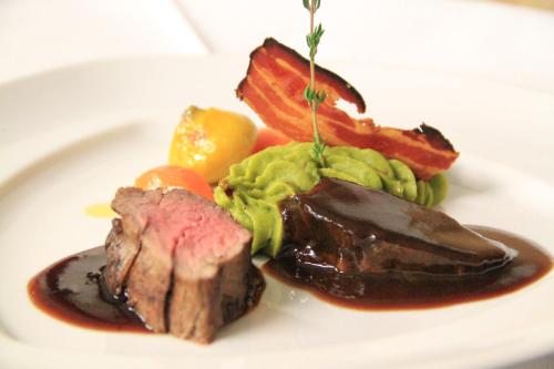 a plate of food with meat and vegetables on it at Hotel Gspan in Arosa