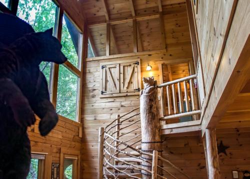 a tree house with a cat standing on a ladder at Hoot n Hollar #31 in Sevierville