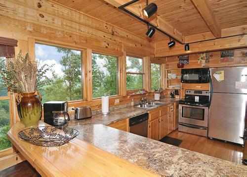uma grande cozinha com paredes de madeira e balcões de madeira em Halfway to Heaven #40 em Sevierville