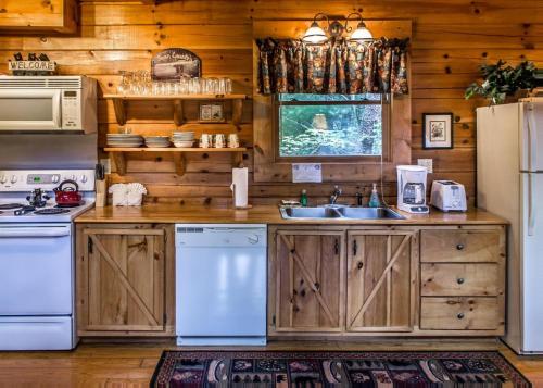 a kitchen with wooden cabinets and a white refrigerator at Bear Hug #18 in Sevierville