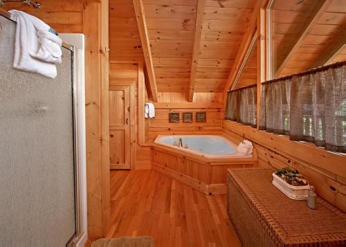 a large bathroom with a tub in a log cabin at Above It All #38 in Sevierville