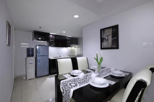 a kitchen and dining room with a table and chairs at Horison Ultima Suite & Residences Rasuna Jakarta in Jakarta