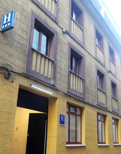 a building with a yellow door and windows at Nap Carta Puebla in Oviedo