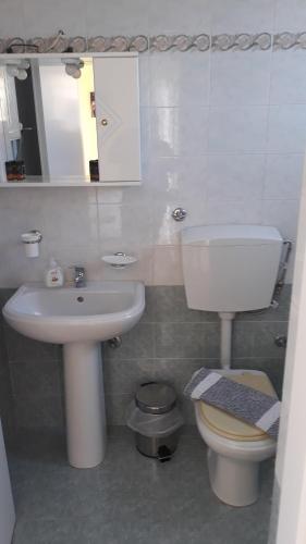 a bathroom with a sink and a toilet and a mirror at Olympic View Guesthouse in Kalami