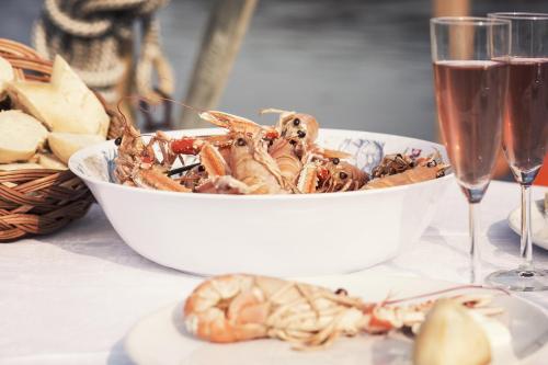 a bowl of seafood on a table with glasses of wine at Kajkanten Vrångö in Vrångö