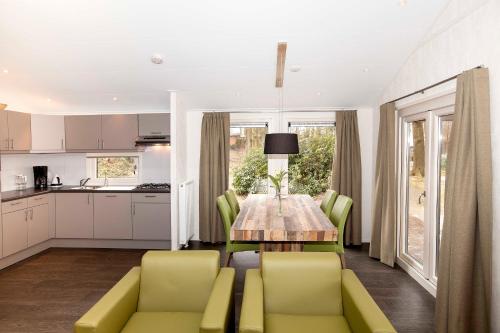 een keuken en eetkamer met een tafel en stoelen bij Hoeve Springendal Erf&Bron in Hezingen