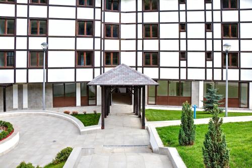 a building with a gazebo in front of it at Brzeće Center Apartments in Kopaonik
