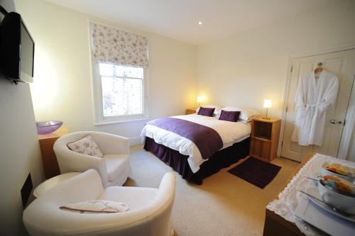 a hotel room with a bed and a robe at The Lilac Door in London