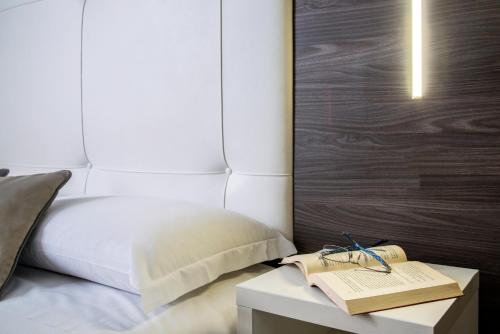 a bedroom with a bed and a table with a book at Ibis Styles Milano Centro in Milan